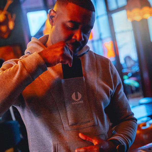 model taking phone out of men's grey ucore hoodie
