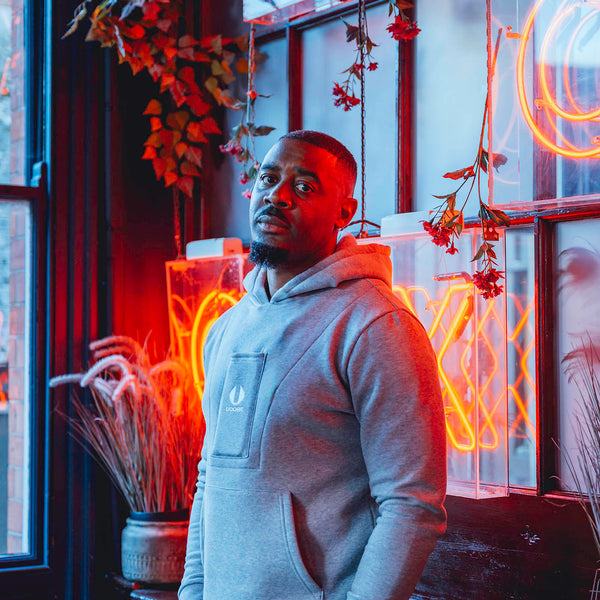 man standing and wearing grey ucore hoodie